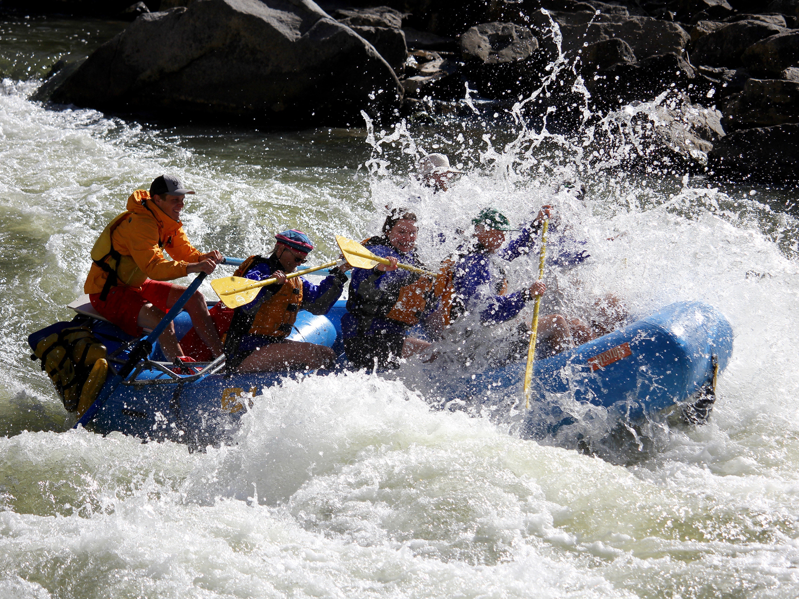 In this image, three guests and their guide revel in an exhilarating rafting adventure on the Colorado River.