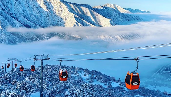 Embrace the winter enchantment with this captivating image of the Adventure Park Gondola. Against a backdrop of snow-covered mountains and ethereal clouds, the vibrant orange gondola cars stand out in the foreground, ready to transport adventurers to a world of snowy thrills. Experience the magic of winter vistas and outdoor excitement with the iconic gondola as your gateway to the mountain wonderland.