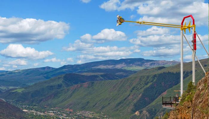 Experience the exhilaration of a theme-park ride at Glenwood Caverns Adventure Park through this captivating photo. Perched on the mountain's edge, the ride provides a thrilling view of the charming town of Glenwood Springs.